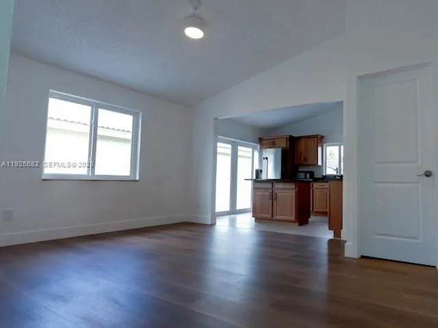a view of kitchen with microwave a stove and wooden floor