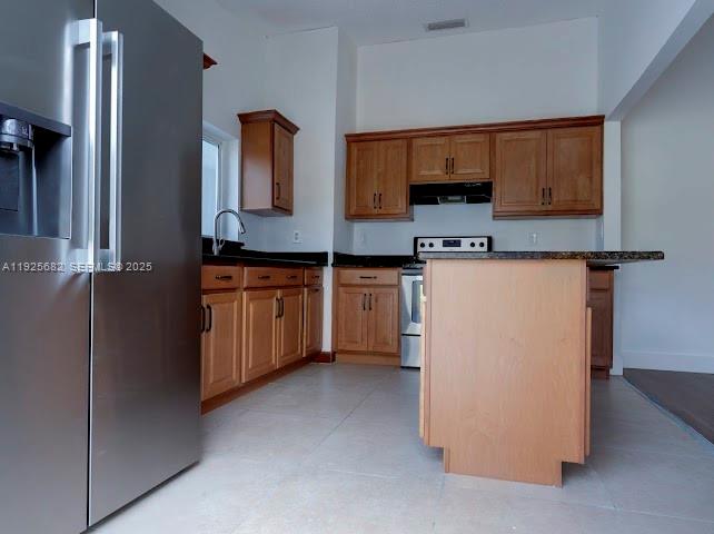 11475 Southwest 181st Street, Unit A Miami, FL 33157 - Photo 7 of 18 a kitchen with stainless steel appliances a refrigerator and a stove top oven