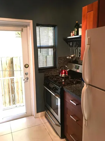 a kitchen with granite countertop a refrigerator and a stove