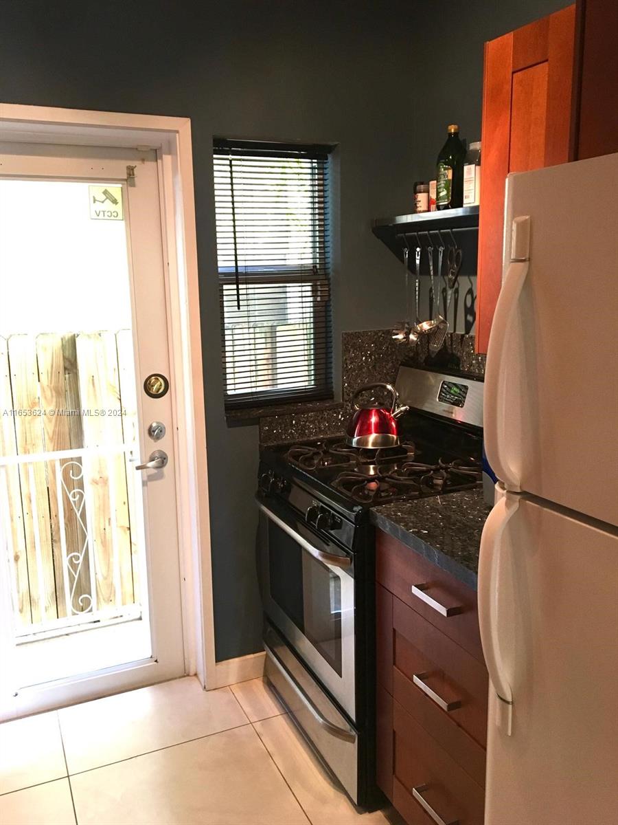 1228 Pennsylvania Avenue, Unit 2 Miami Beach, FL 33139 - Photo 8 of 9 a kitchen with granite countertop a refrigerator and a stove