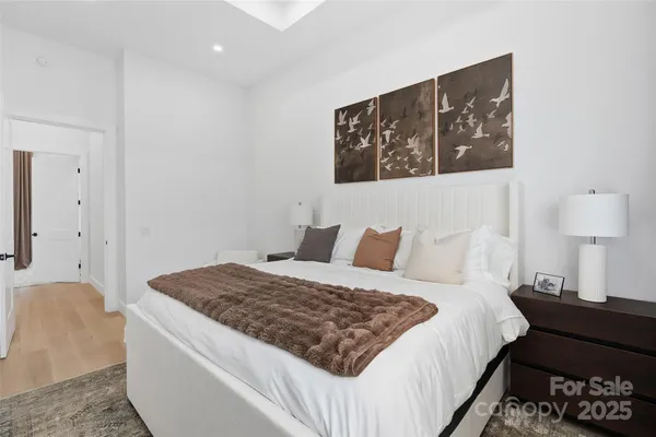 a bedroom with a bed and a lamp on dresser