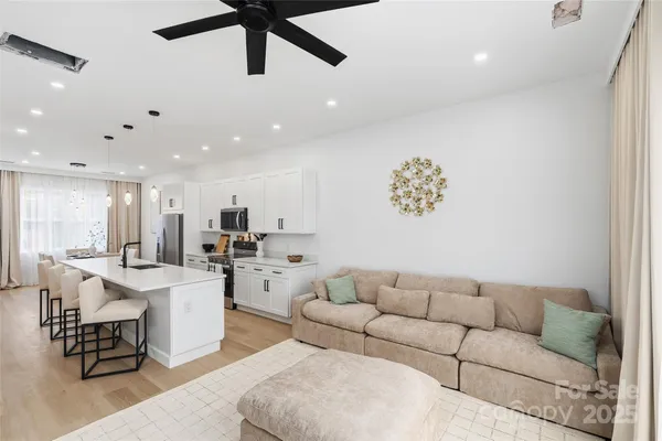 a living room with furniture and kitchen view