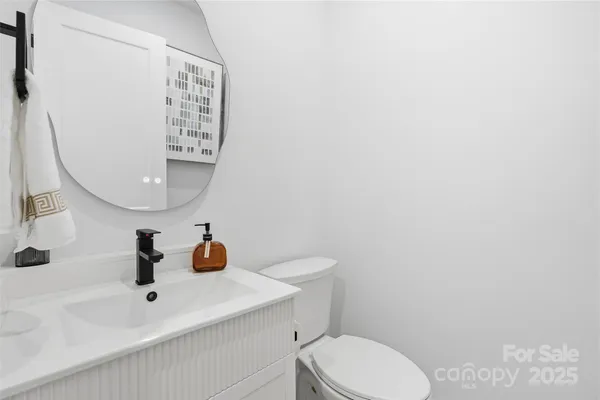 a bathroom with a sink a toilet and mirror