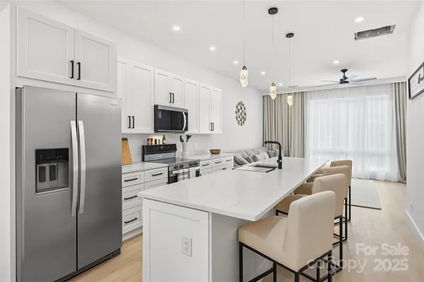 a kitchen with refrigerator a sink dishwasher a stove and a refrigerator with wooden floor