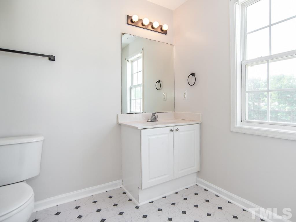3824 Pin Oak Road Raleigh, NC 27604 - Photo 18 of 27 a bathroom with a sink a toilet and a window