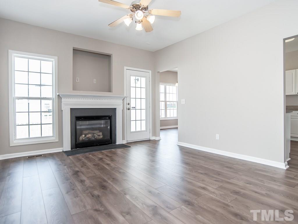 3824 Pin Oak Road Raleigh, NC 27604 - Photo 3 of 27 an empty room with wooden floor fireplace and windows