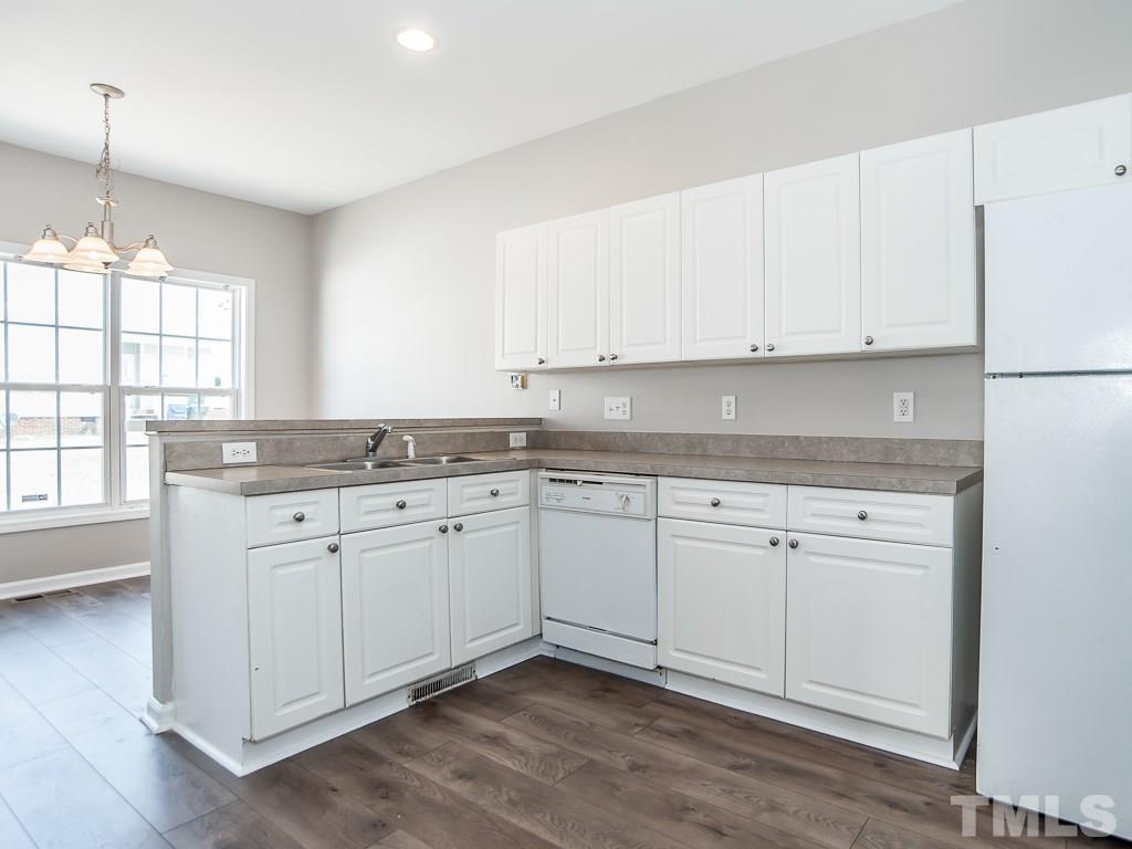 3824 Pin Oak Road Raleigh, NC 27604 - Photo 7 of 27 a kitchen with granite countertop white cabinets and white appliances