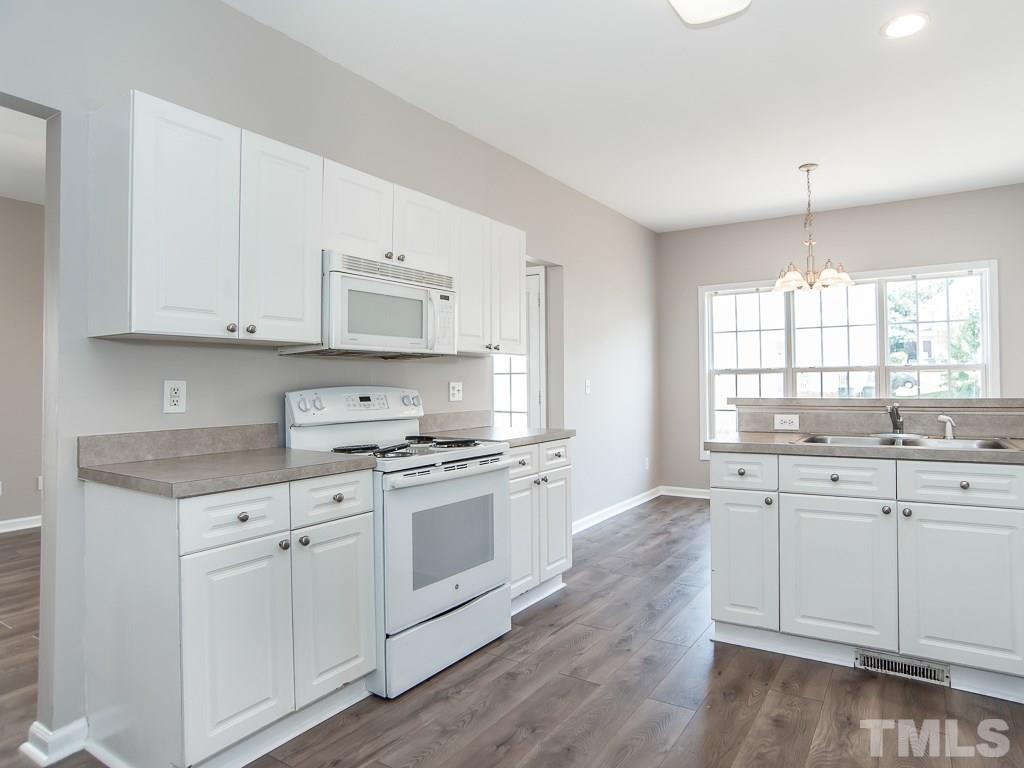 3824 Pin Oak Road Raleigh, NC 27604 - Photo 8 of 27 a kitchen with granite countertop white cabinets and white appliances