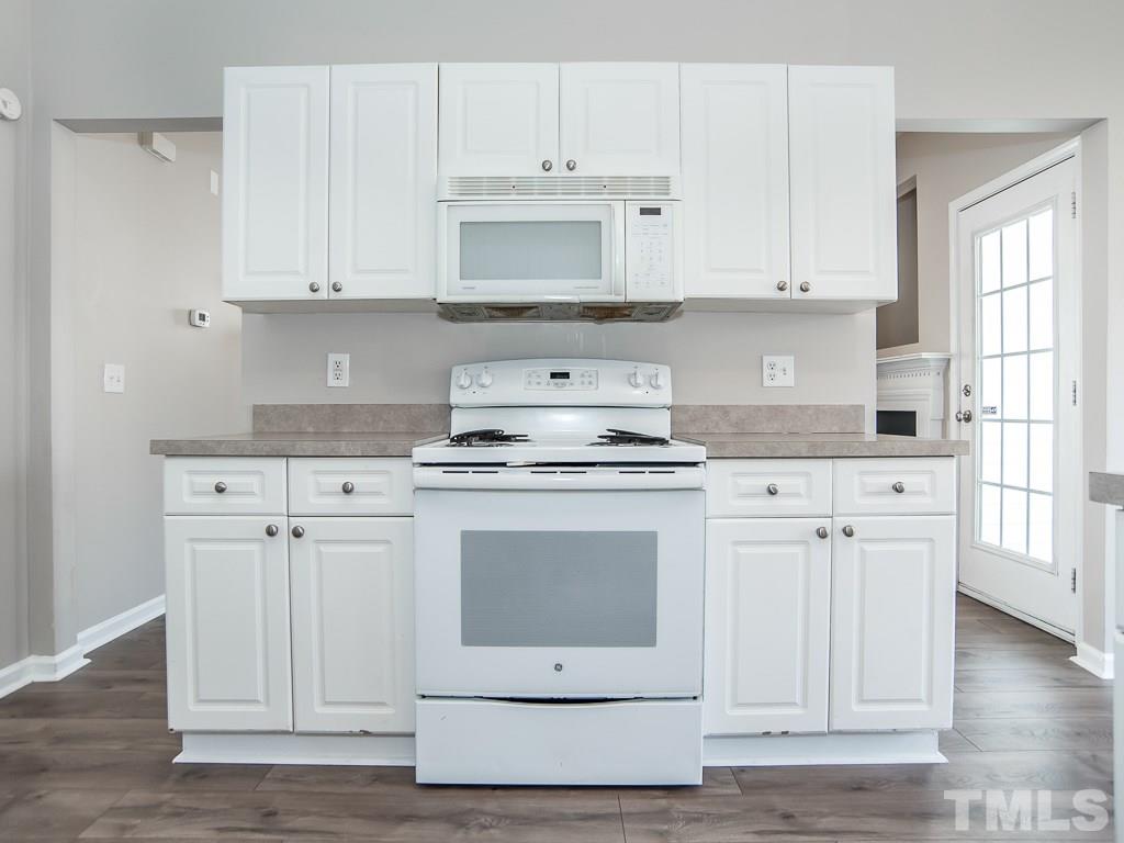3824 Pin Oak Road Raleigh, NC 27604 - Photo 9 of 27 a kitchen with white cabinets and white appliances