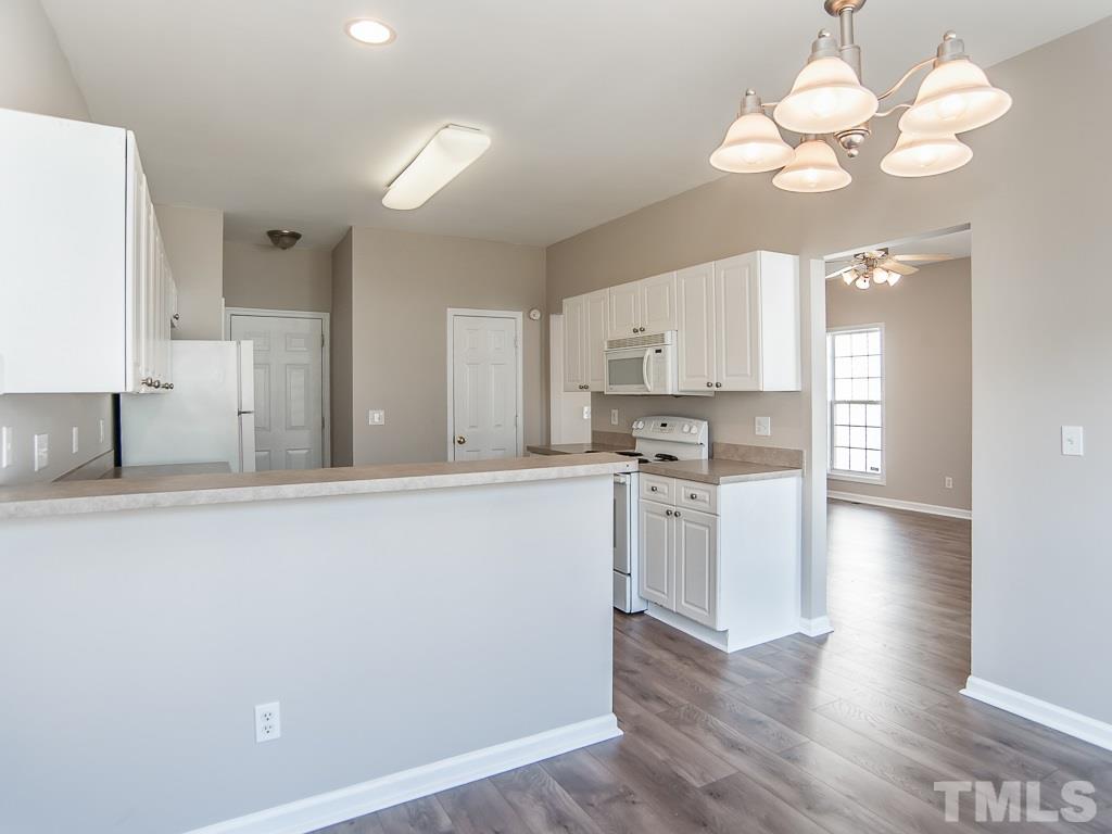 3824 Pin Oak Road Raleigh, NC 27604 - Photo 10 of 27 a large kitchen with cabinets wooden floor and stainless steel appliances