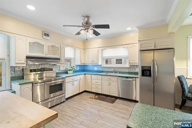 a kitchen with stainless steel appliances granite countertop a refrigerator a stove microwave and cabinets