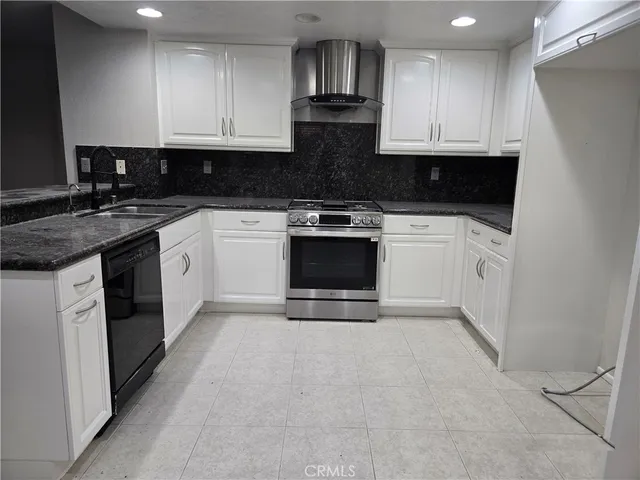 a kitchen with granite countertop a stove and a sink