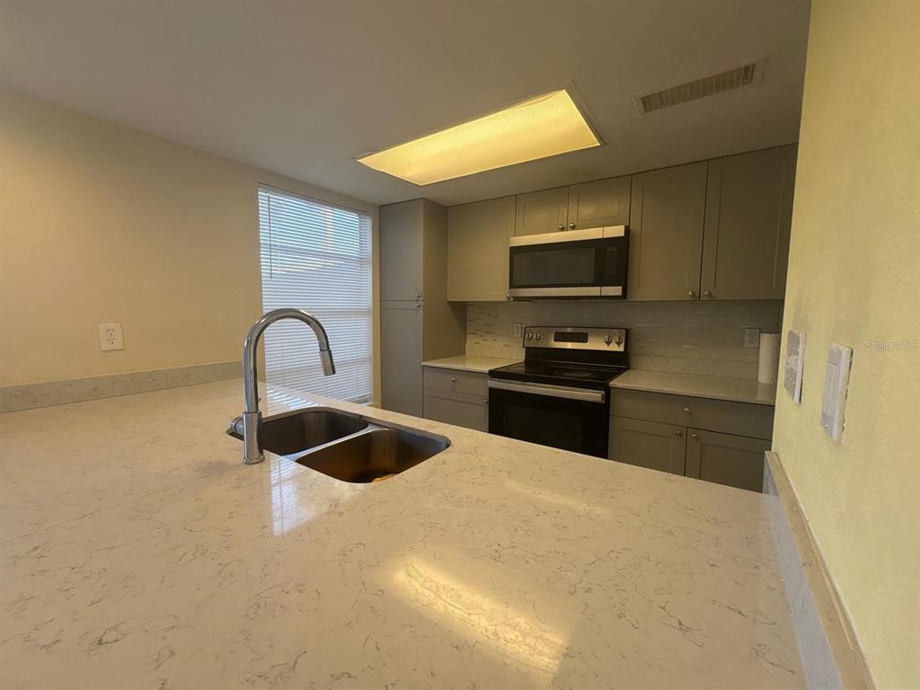 4033 Henley Road, Unit 1707 Orlando, FL 32839 - Photo 37 of 66 a kitchen with granite countertop a stove and a refrigerator