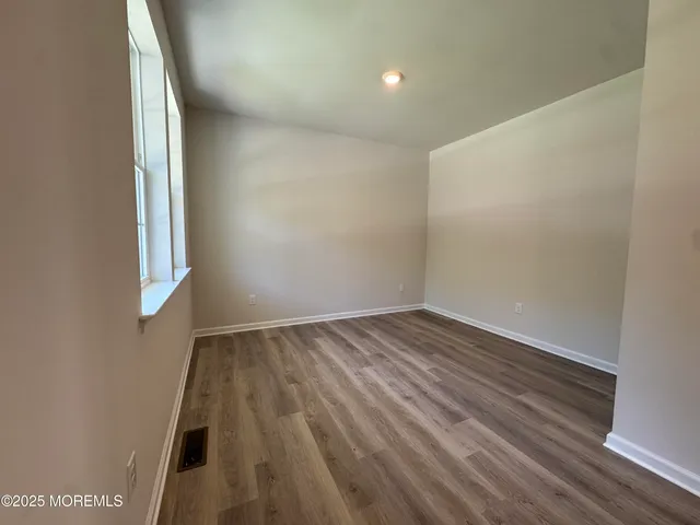 a view of an empty room and wooden floor