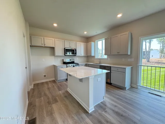 a kitchen with a sink a counter top space stainless steel appliances and a window