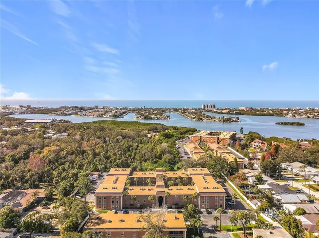 an aerial view of a city with lots of residential buildings and ocean view in back