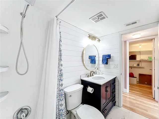 a bathroom with a sink vanity mirror and toilet