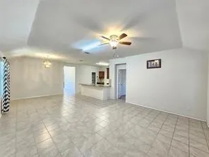 a view of a big room with windows and chandelier fan