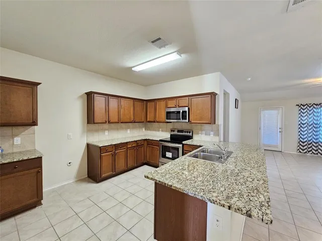 a large kitchen with granite countertop cabinets and steel stainless steel appliances