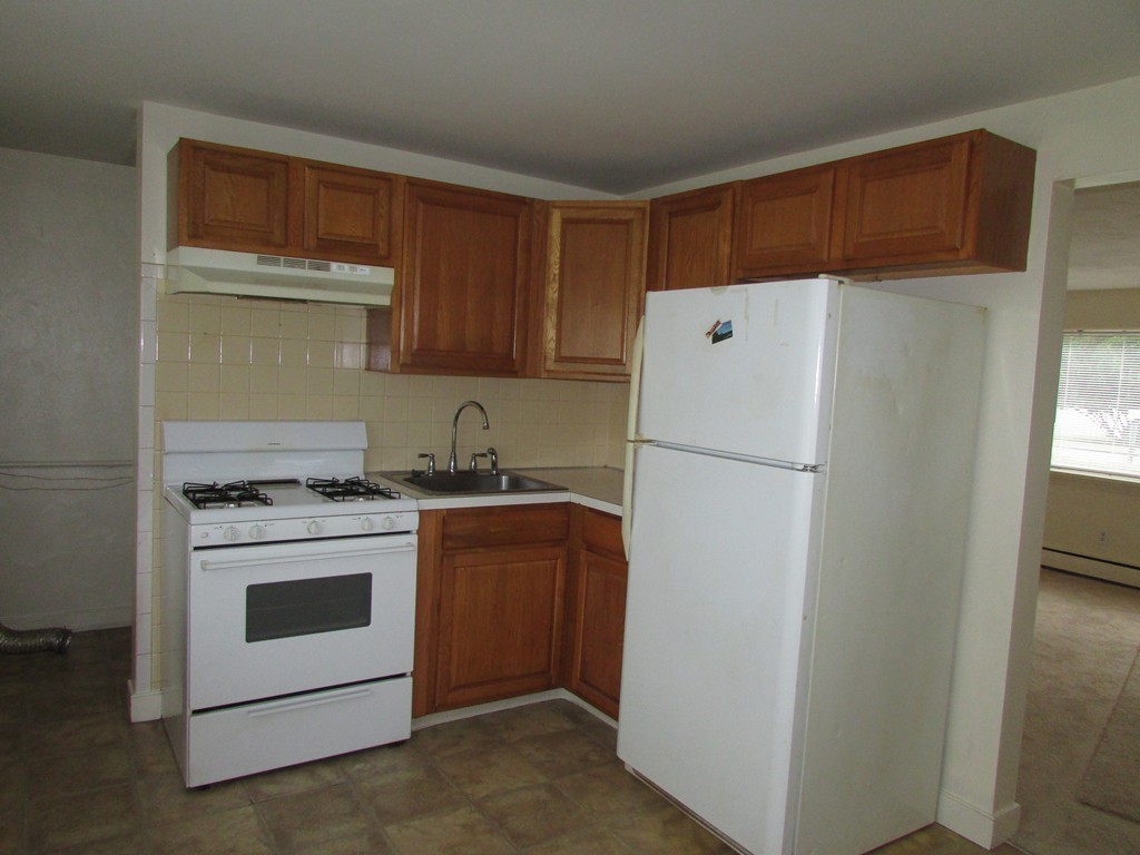 12 Chatham Road Billerica, MA 01821 - Photo 4 of 16 a white refrigerator freezer and a stove sitting inside of a kitchen