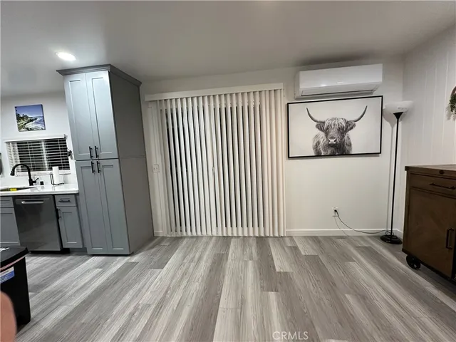 a view of a hallway with wooden floor and a livingroom