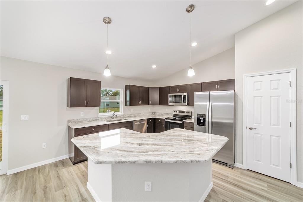 7866 North Manville Road Citrus Springs, FL 34434 - Photo 4 of 19 a kitchen with kitchen island a sink stainless steel appliances and cabinets