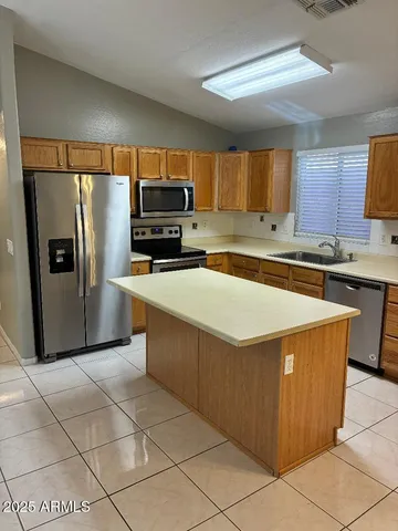 a kitchen with stainless steel appliances a refrigerator sink and microwave