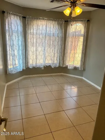 a view of an empty room with a window and chandelier