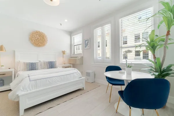 a bedroom with a large bed and a potted plant