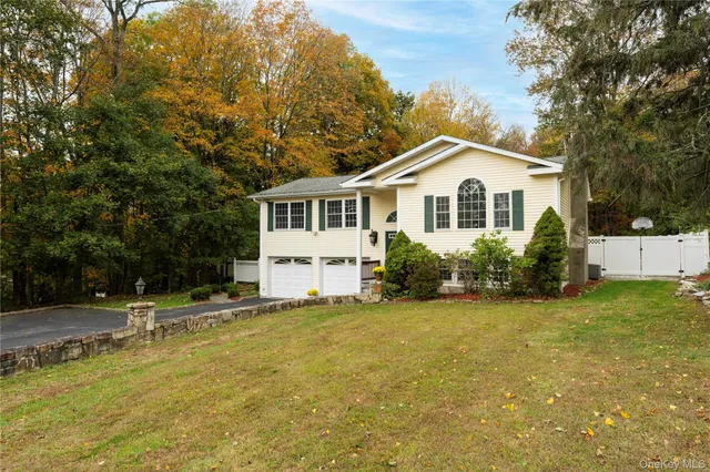 a front view of a house with a yard and potted plants