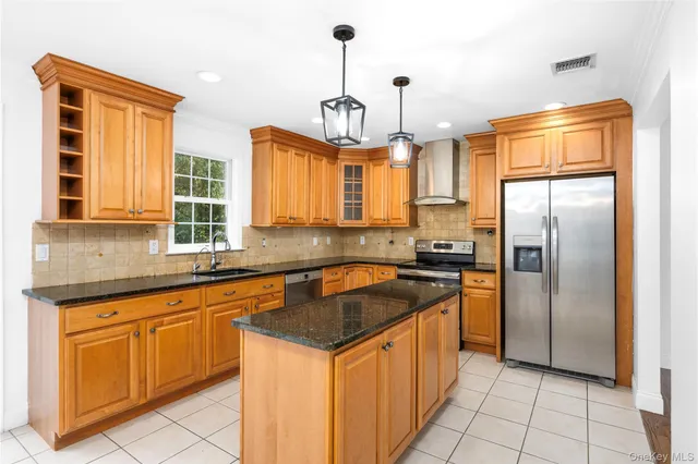a kitchen with granite countertop stainless steel appliances a sink a counter top space cabinets and a window