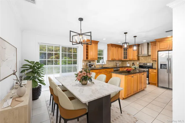 a large kitchen with granite countertop a stove a sink dishwasher a refrigerator and wooden cabinets with wooden floor