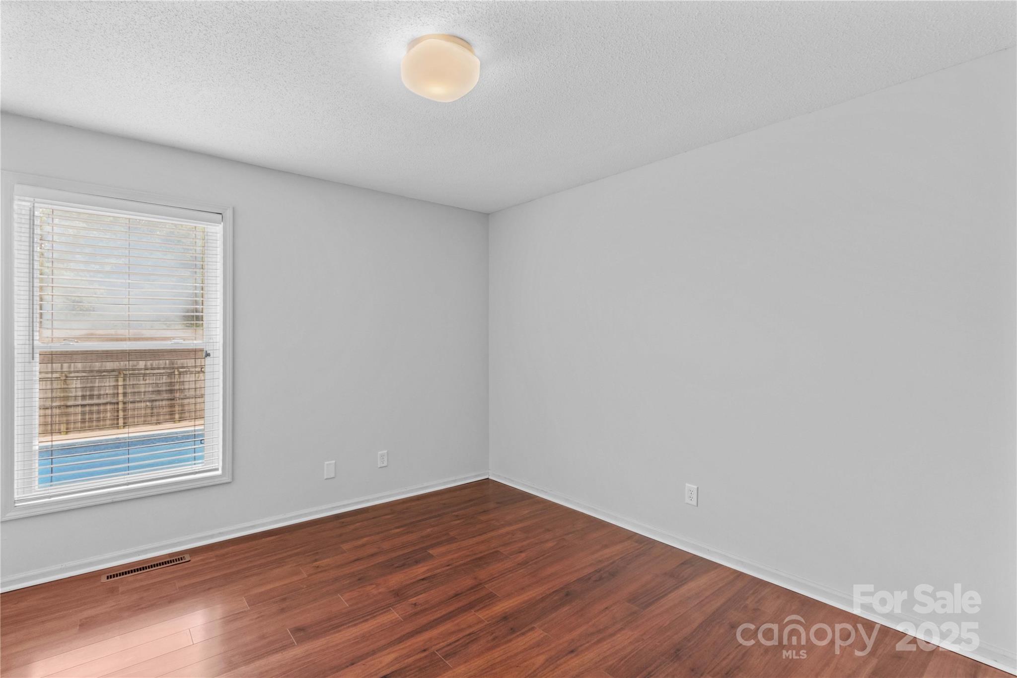 296 Hicks Creek Road Troutman, NC 28166 - Photo 21 of 48 a view of an empty room with wooden floor and a window