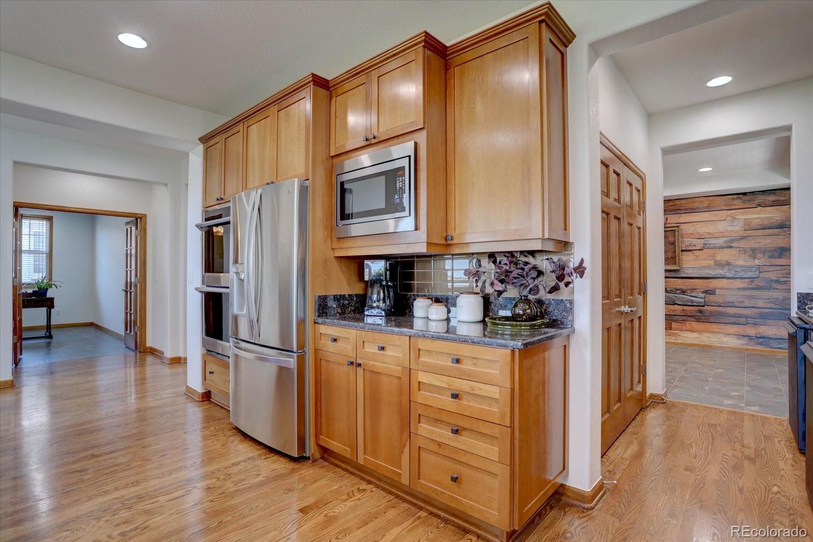 2795 Rockbridge Circle Highlands Ranch, CO 80129 - Photo 13 of 49 a kitchen with stainless steel appliances granite countertop a refrigerator and a stove top oven