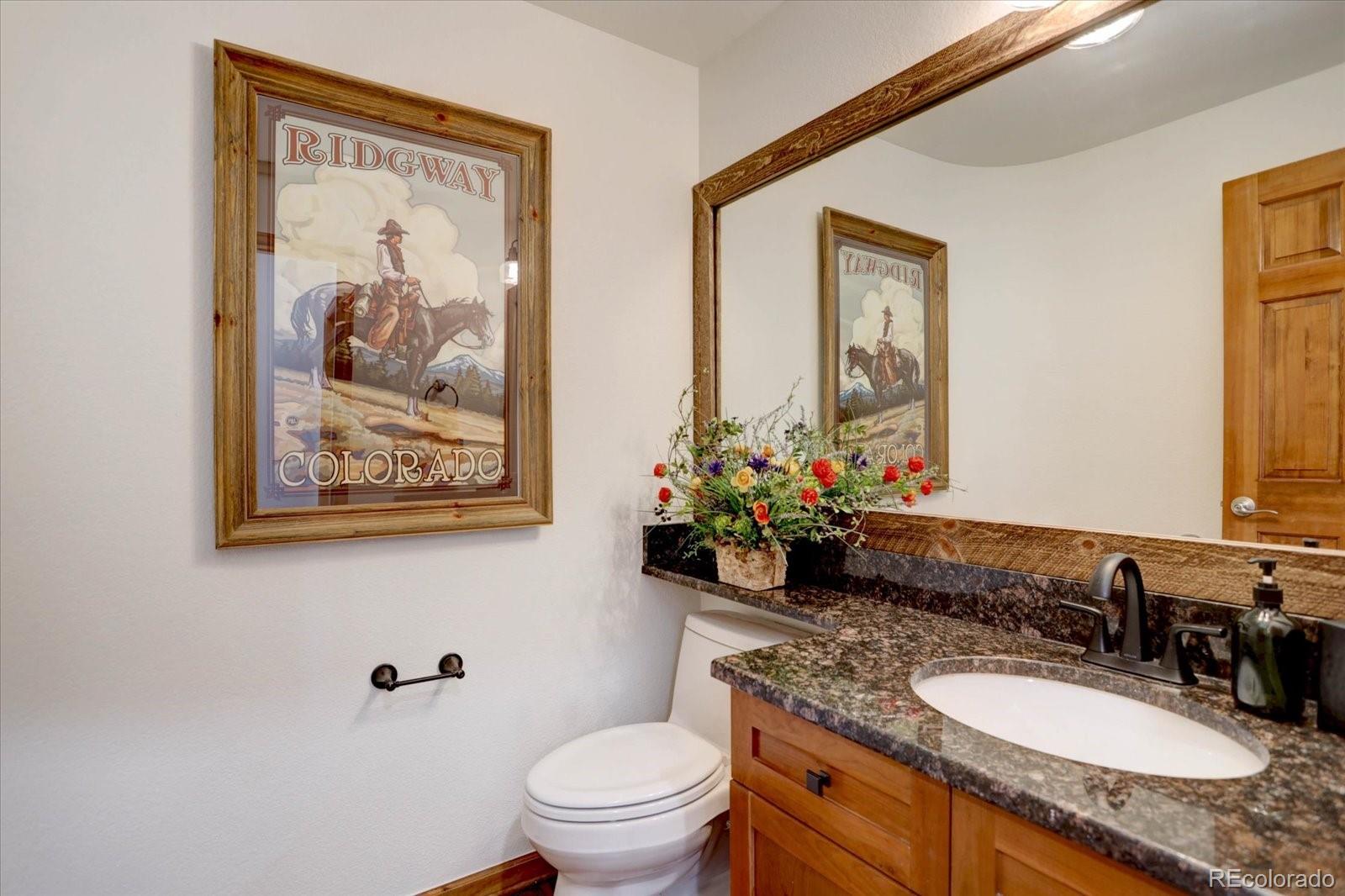 2795 Rockbridge Circle Highlands Ranch, CO 80129 - Photo 21 of 49 a bathroom with a granite countertop sink a toilet and a mirror