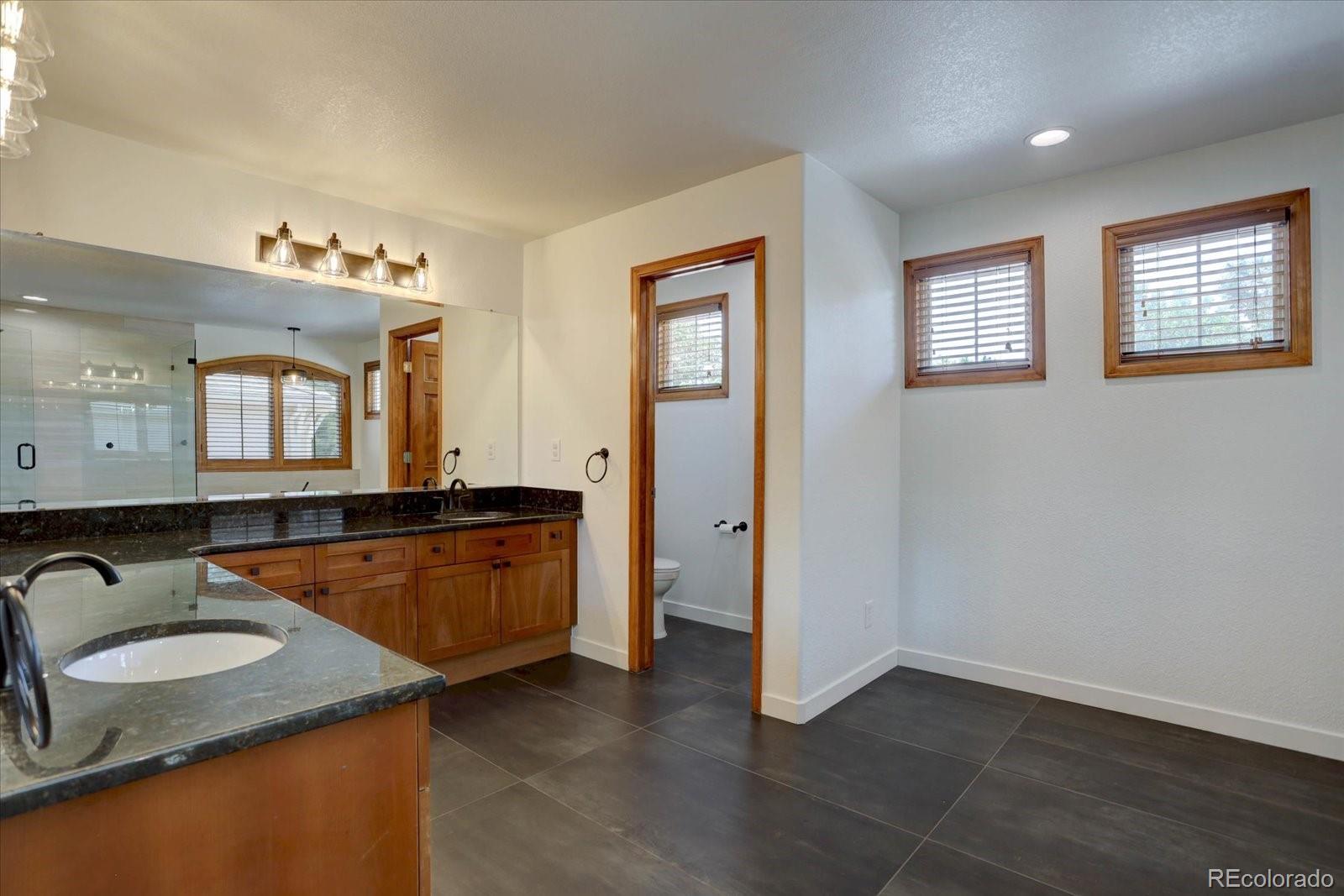 2795 Rockbridge Circle Highlands Ranch, CO 80129 - Photo 29 of 49 a bathroom with a granite countertop sink and a mirror