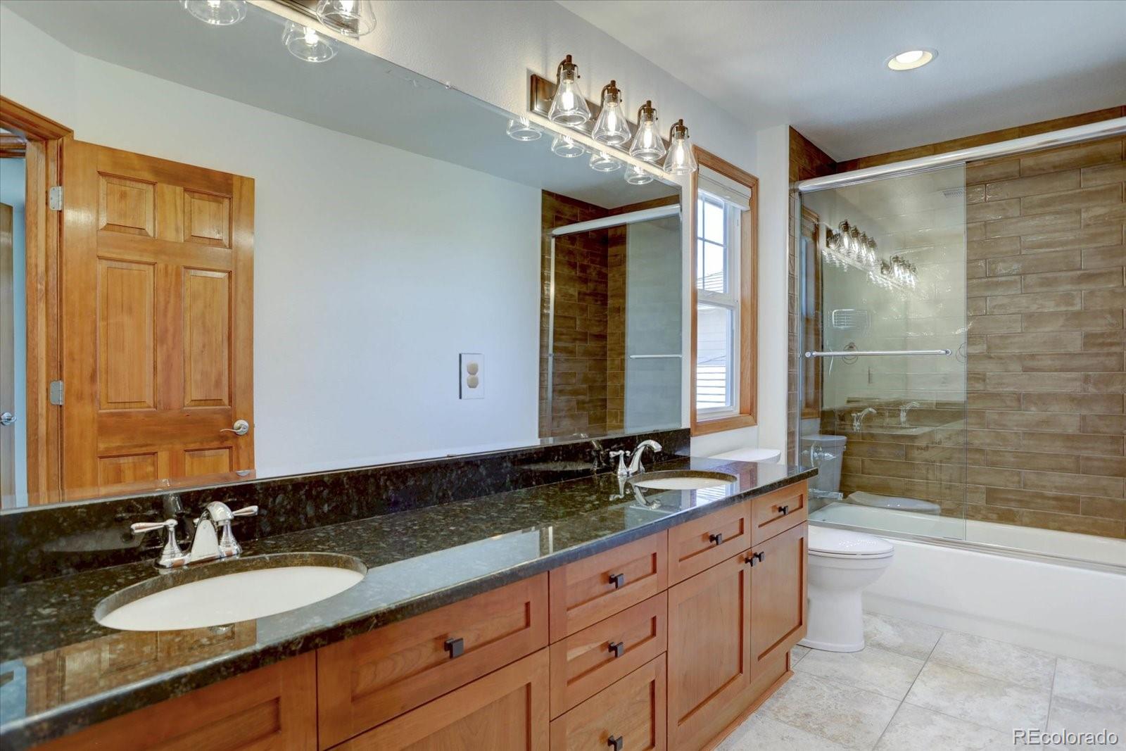 2795 Rockbridge Circle Highlands Ranch, CO 80129 - Photo 32 of 49 a bathroom with double vanity sinks and a bathtub
