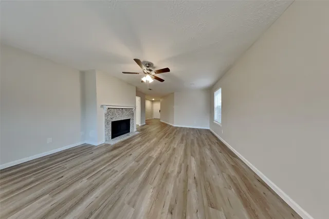 a view of empty room with wooden floor and fireplace