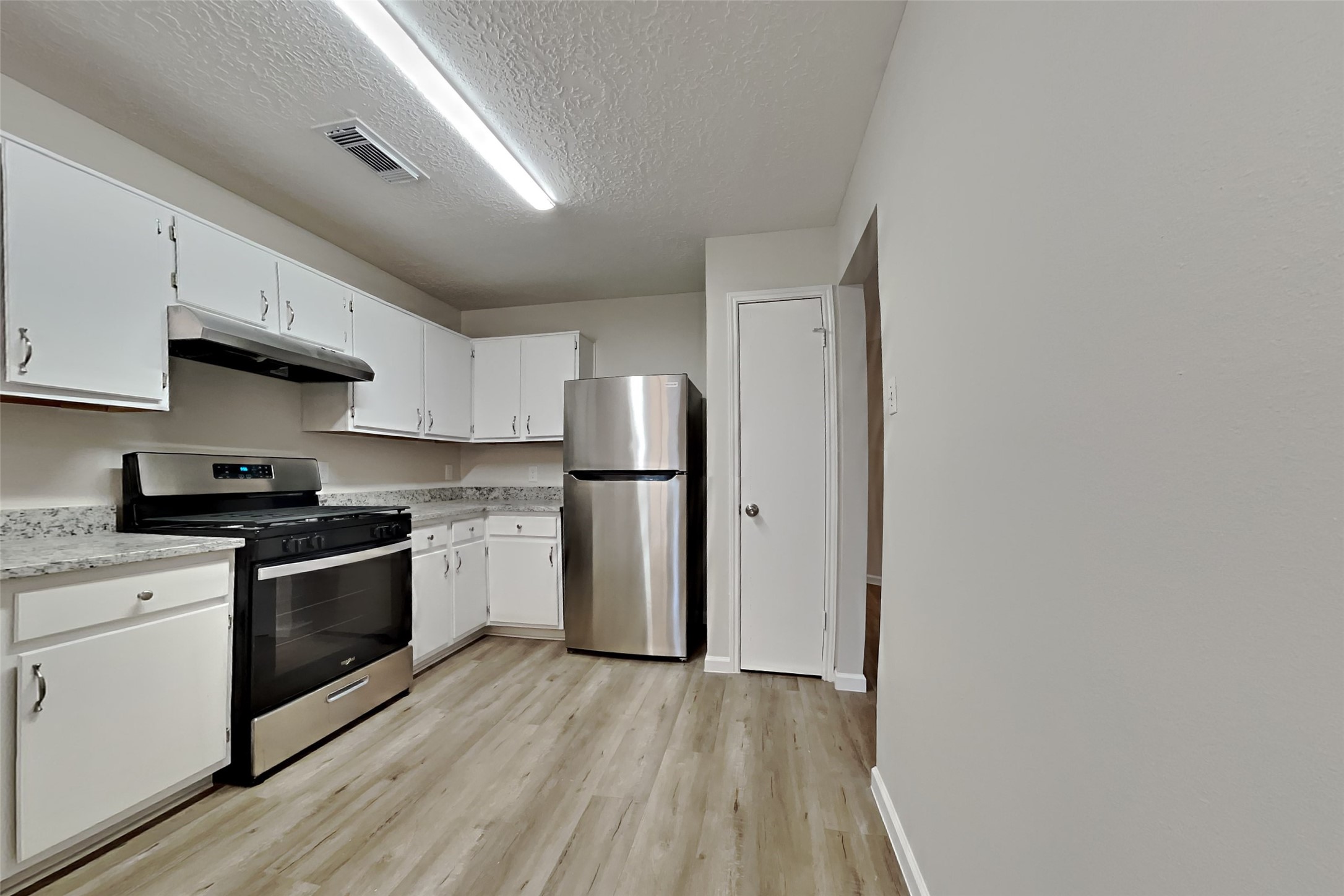 30806 Melita Drive Spring, TX 77386 - Photo 4 of 18 a kitchen with stainless steel appliances granite countertop a stove a sink and a refrigerator