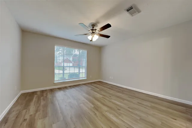 wooden floor in an empty room with a window