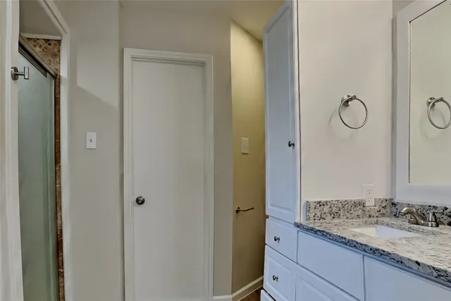 a bathroom with a granite countertop sink and a mirror