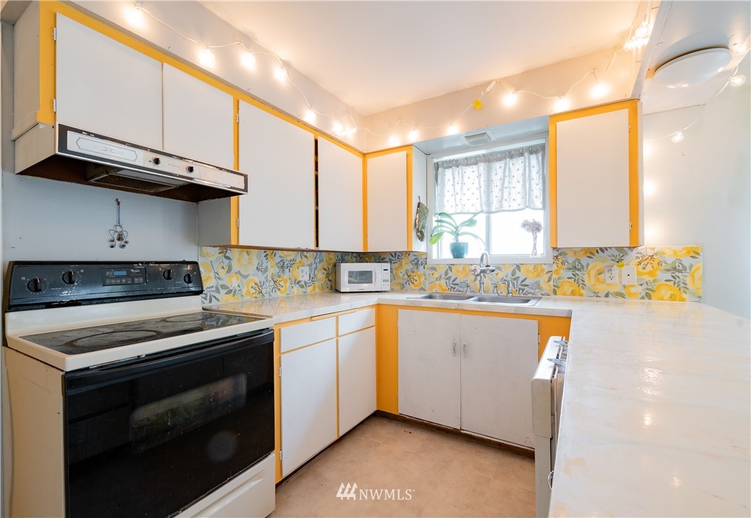 9641 Delta Line Road Blaine, WA 98230 - Photo 8 of 26 a kitchen with stainless steel appliances granite countertop a stove a sink and a microwave