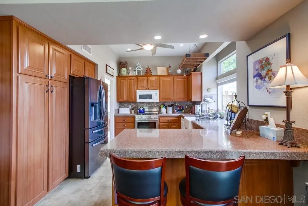 930 Gardena Road Encinitas, CA 92024 - Photo 11 of 40 a dining table with chairs and a refrigerator