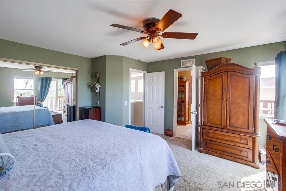 930 Gardena Road Encinitas, CA 92024 - Photo 21 of 40 a bedroom with a large bed and a chandelier