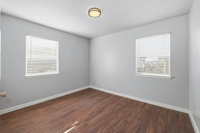 a view of a room with wooden floor and windows