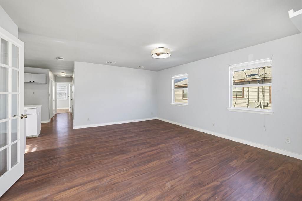 213 West Davis Street Kerrville, TX 78028 - Photo 2 of 17 wooden floor in an empty room with a window