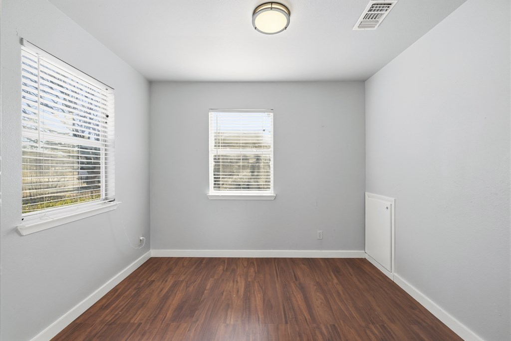 213 West Davis Street Kerrville, TX 78028 - Photo 4 of 17 an empty room with wooden floor and windows