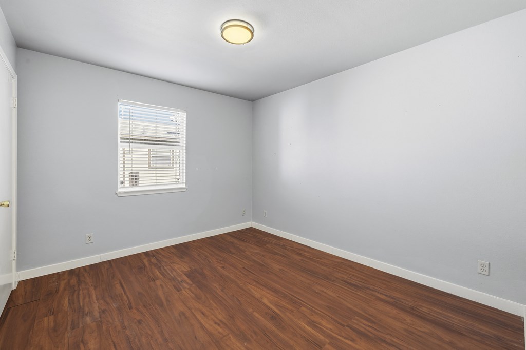 213 West Davis Street Kerrville, TX 78028 - Photo 10 of 17 an empty room with wooden floor and windows