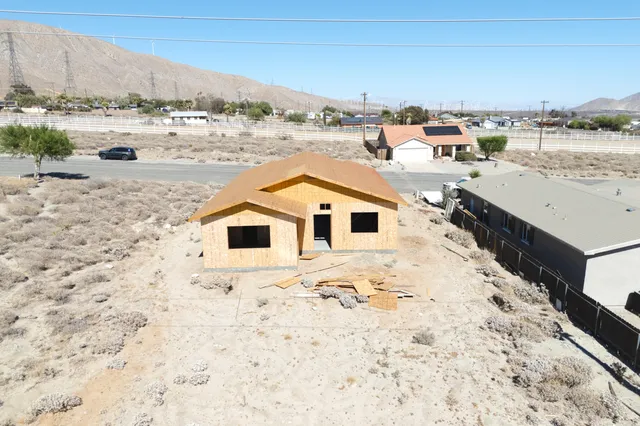 a view of a dry yard with wooden fence
