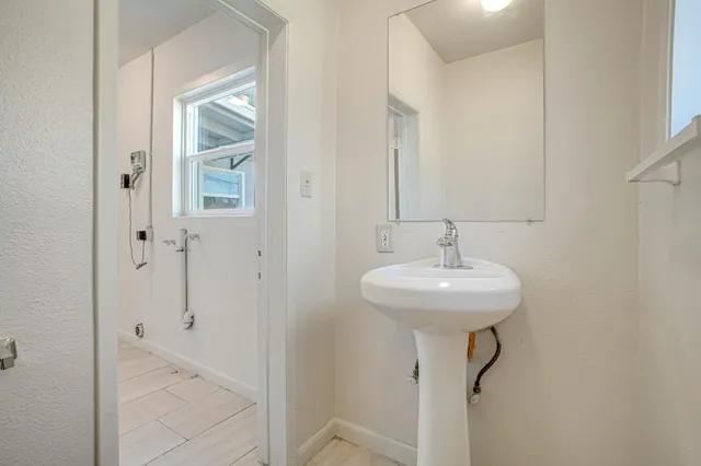 a bathroom with a sink a toilet and mirror